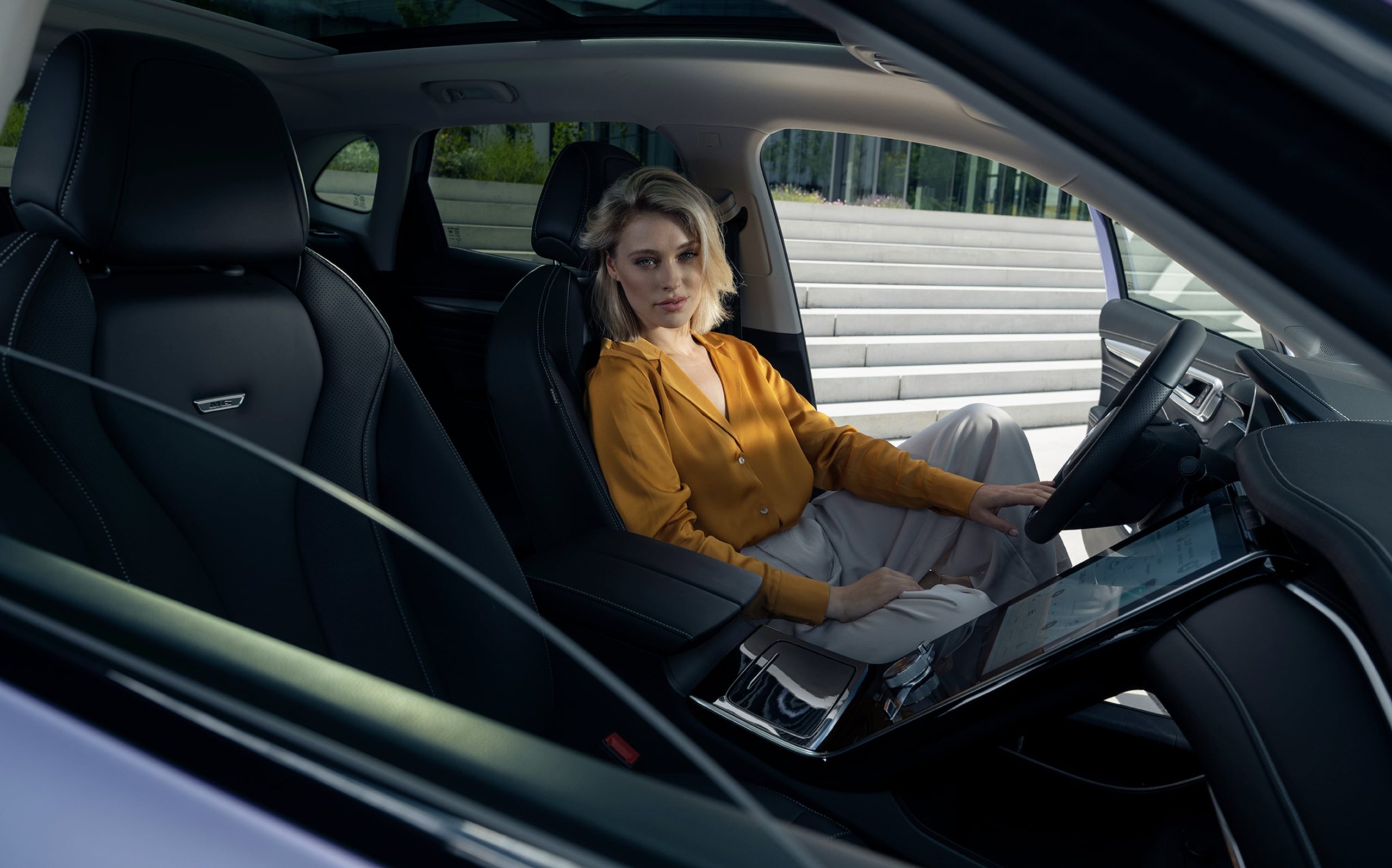 A woman sitting on the driver's seat of an MG Marvel R
