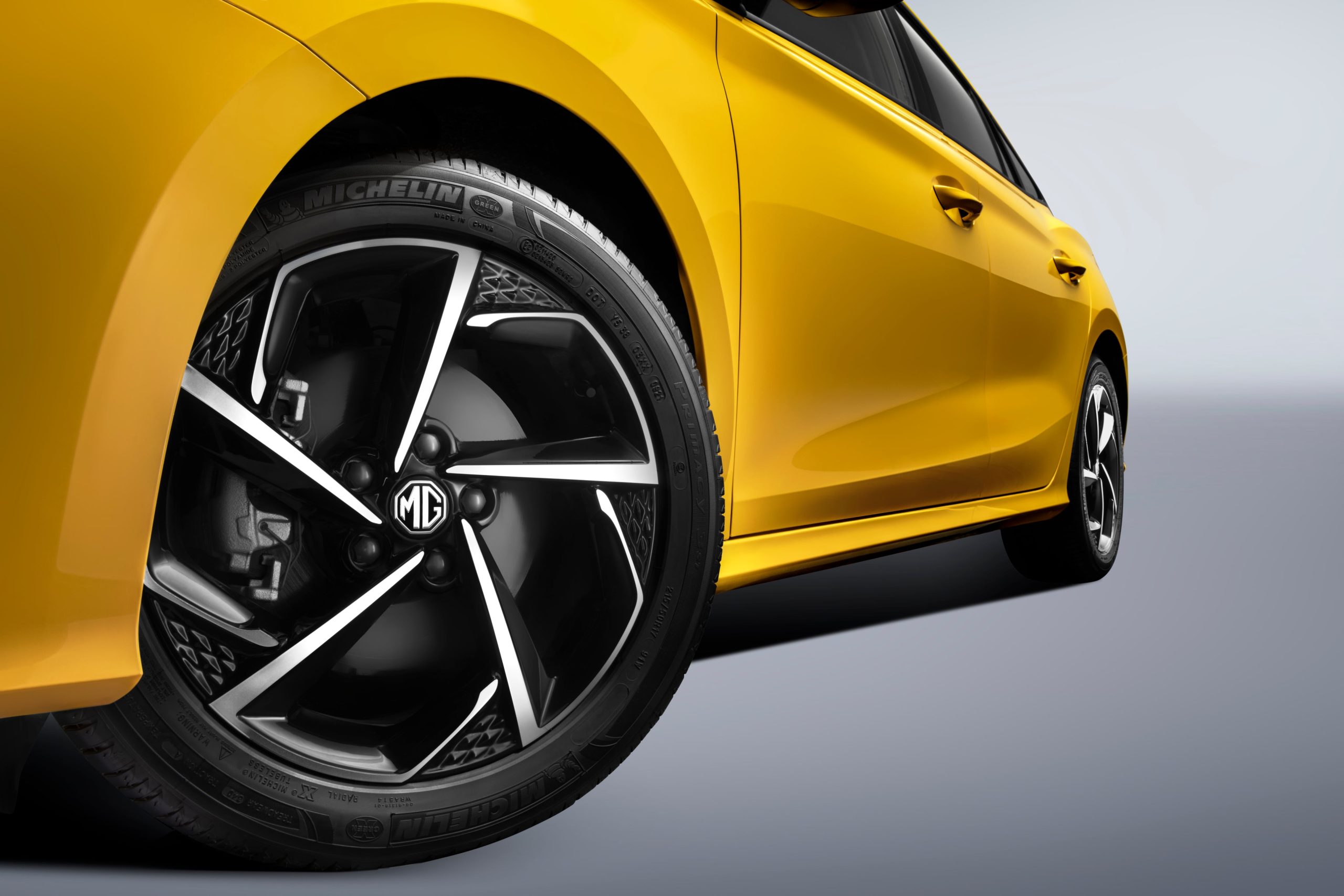 Image of closeup of rear wheel of yellow MG GT