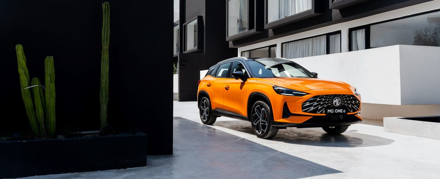 Image of orange MG One parked in front of apartments