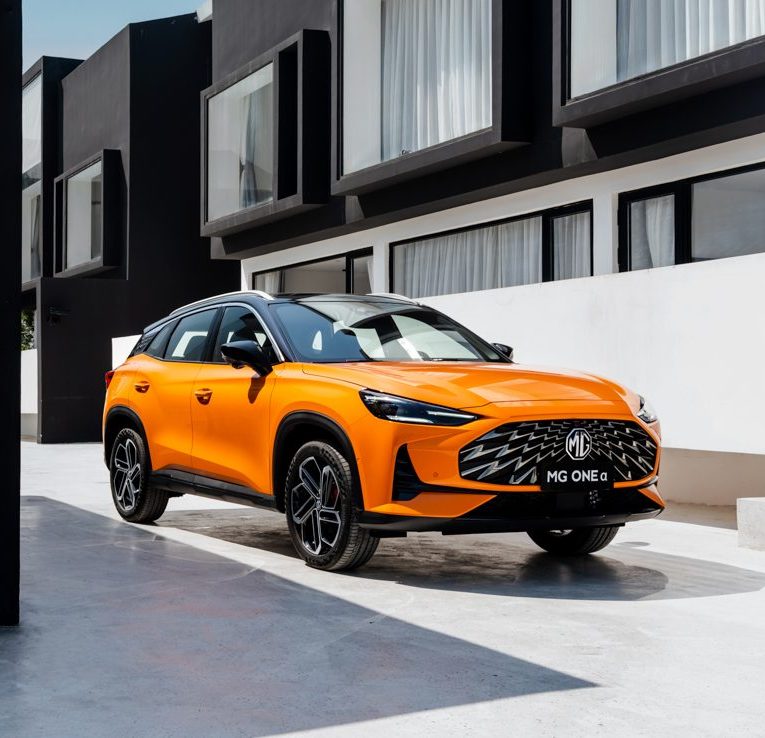 Image of orange MG One parked in front of apartments