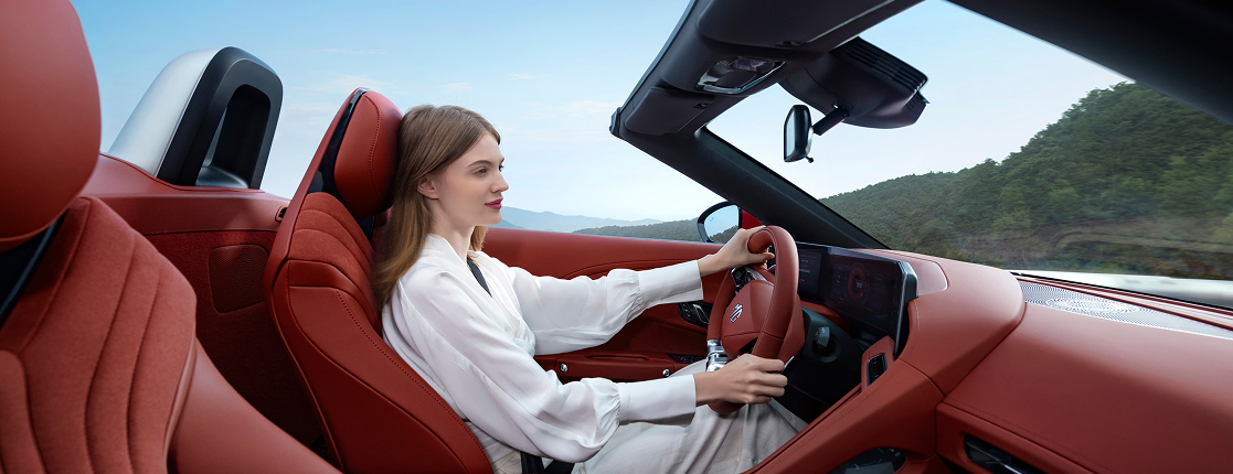 A woman driving a red MG Cyberster EV