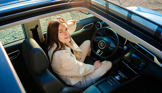 Image of woman in the driver's seat looking out the MG ZS EV's sunroof.