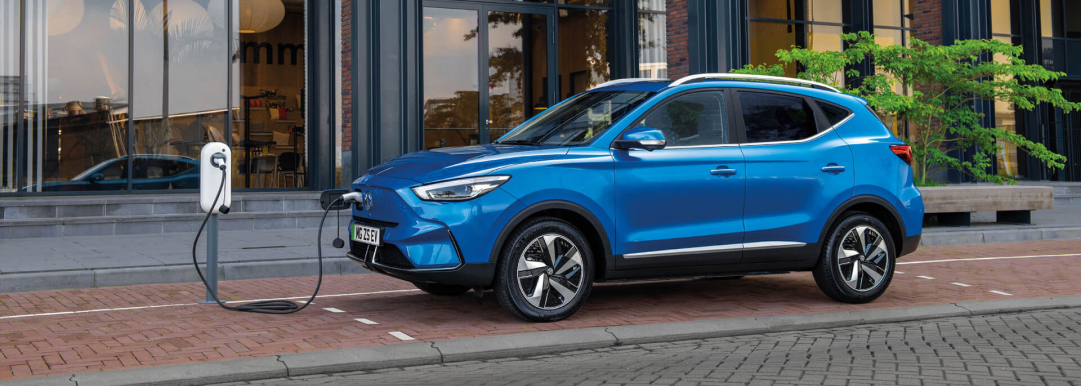 Image of blue MG ZS EV parked and charging on the side of the road.
