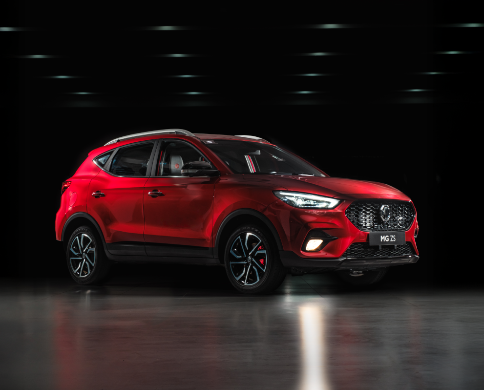 Image of three-quarter view of red MG ZS against a dark background.