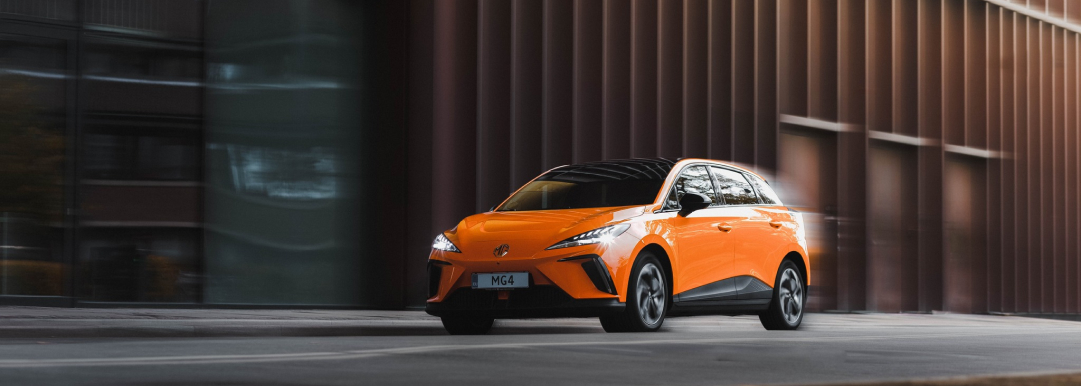 Image of orange MG 4 EV in motion on a city road
