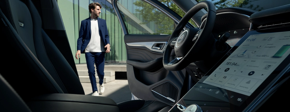 A man walking towards the entrance of MG Marvel R on the side of the driver's seat