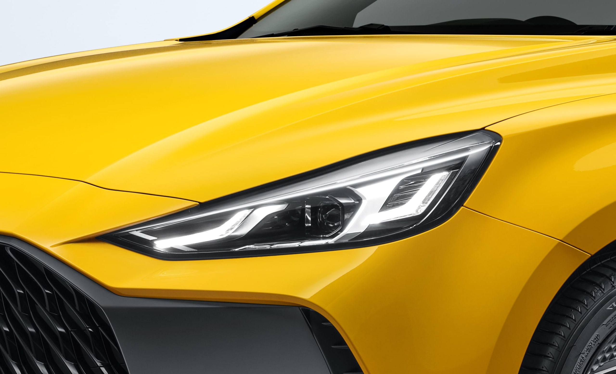 Closeup image of LED headlamps of yellow MG GT